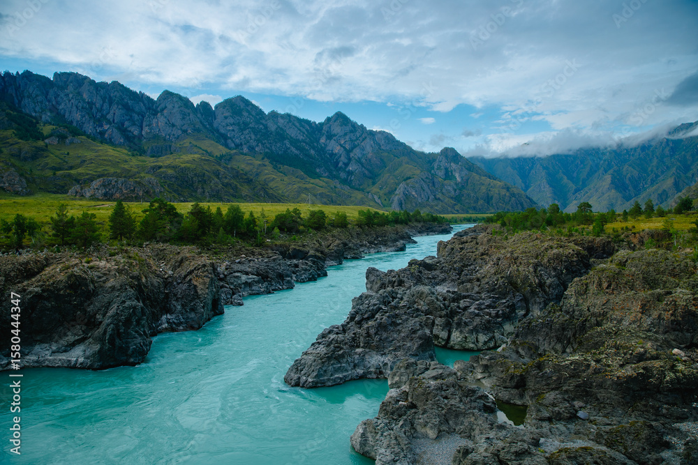Fototapeta premium Scenic Katun mountain river in lush green valley with rugged rocks and dramatic clouds Altay