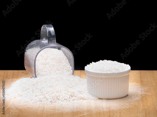 White Rice in Measuring Cup and Bowl on Wooden Surface