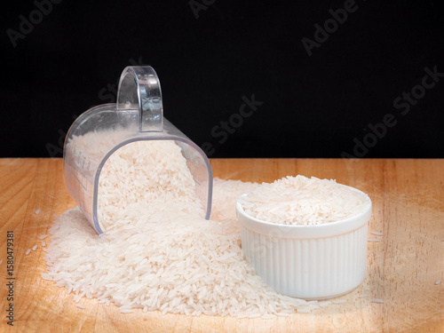 White Rice in Measuring Cup and Bowl on Wooden Surface