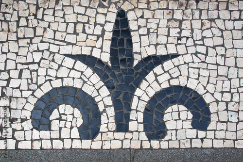 White Portuguese Cobblestone with Black Traditional Pattern. Classic Portuguese white cobblestone pavement with black ornamental pattern, a hallmark of traditional street design and urban aesthetics.