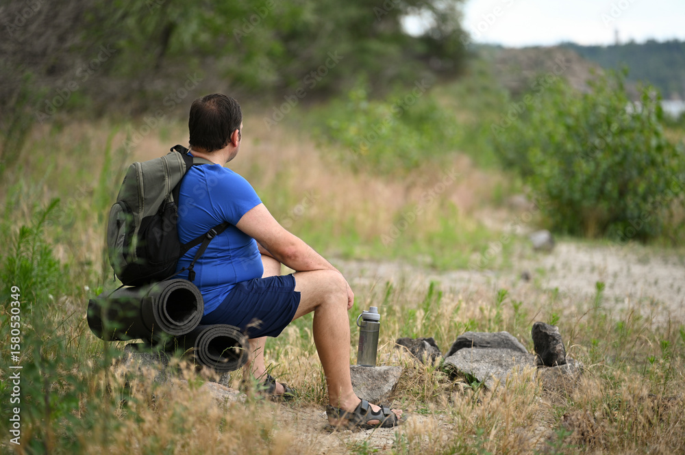 Fototapeta premium A man with a backpack walks through the forest and the beach and does sports