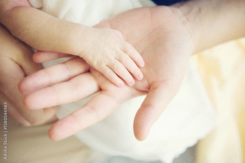 Adult hand with baby hand Adult hand with baby hand