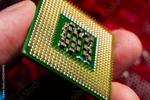 computer support engineer installs a processor. A microprocessor with the silicon core and cache chip clearly visible. Installing a computer processor into a socket