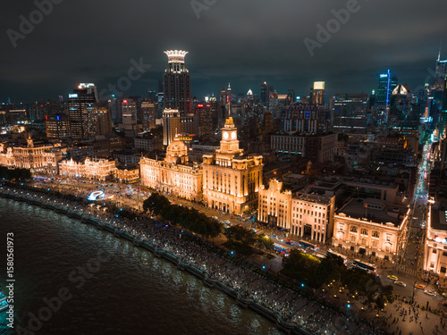 Shanghai, China - 21 June 2025: Aerial view of the Bund's historic architecture shimmering under the night sky, a luminous contrast to the dark waters and distant skyscrapers.
