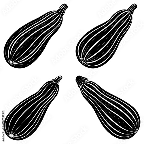 Four black and white zucchinis arranged in a symmetrical pattern on a white background view from above