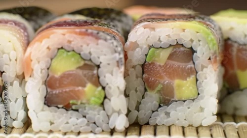 Fresh sushi rolls with salmon and avocado on a white plate