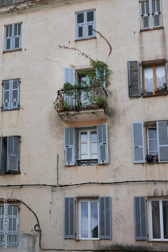 Obraz premium facade of an old house with a balcony an the shutters are opem