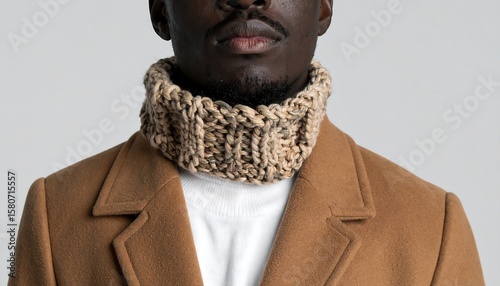 Stylish African Man Wearing Cozy Hand-Knit Scarf and Elegant Brown Overcoat in a Studio Setting