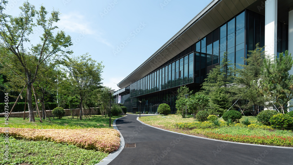 Naklejka premium Modern office building with well-maintained greenery in front