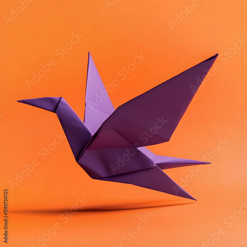 Purple origami paper bird against an orange background 