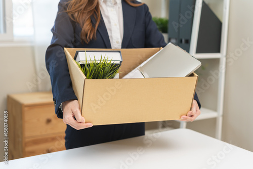 Unemployment, quitting job concept, desperate asian young business woman resigning or fired, leave from company, female holding belongings, stuff into box cardboard, layoff or leaving, changing work.
