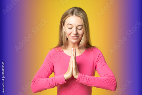 attractive female woman praying with closed eyes with folded together palms. Namaste or prayer gesture, sincerely expressing gratitude for miracle and luck.