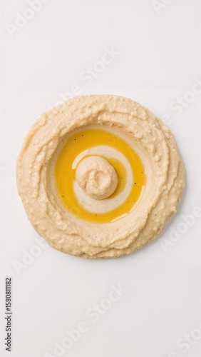 The mellow creaminess of hummus takes on sweetness with a swirl of honey on plain white background