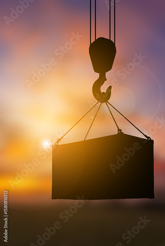 Crane hook lifting container sunset blur background