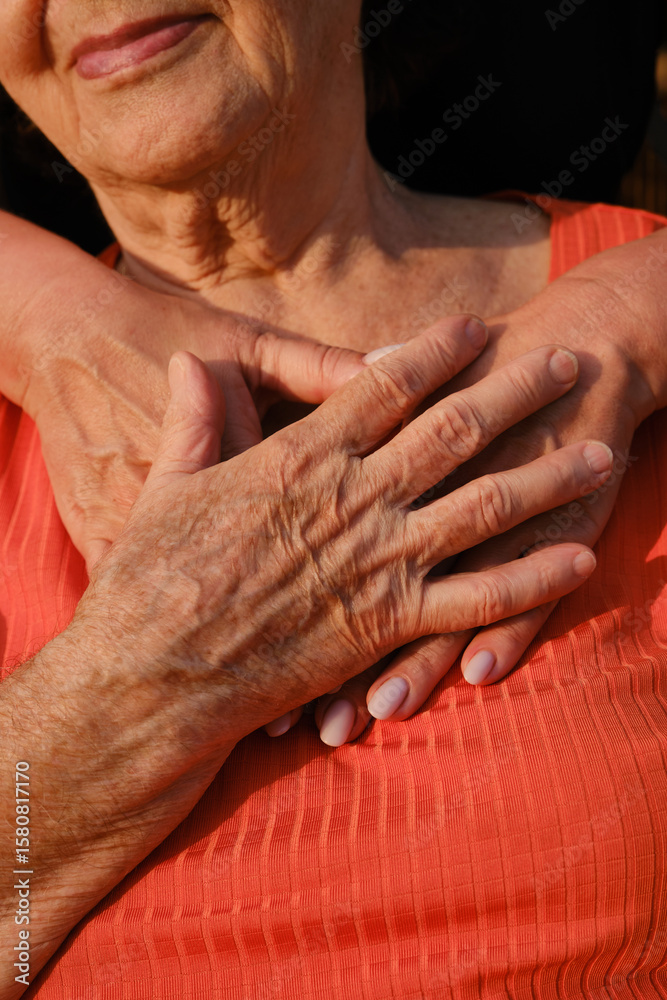Fototapeta premium An adult woman hugs her old mother. Concept of support and care, love, warmth, Mother's day, help.