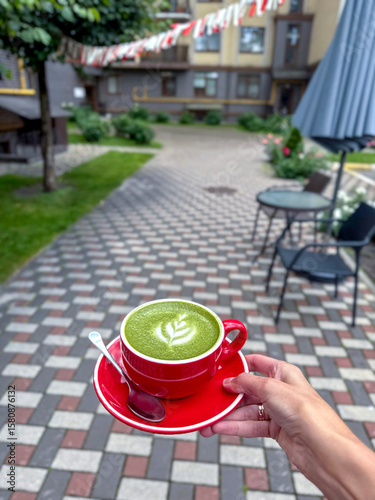 Woman holds matcha cup outside. Peaceful mornings and natural energy boost, slow living, self-care, wellness, health, tea culture and everyday rituals