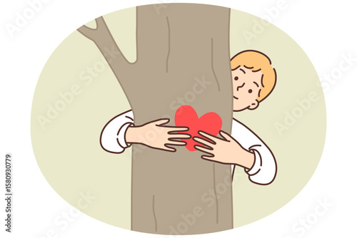 Teenage boy hugging tree is sign of love for ecology and concern for environment