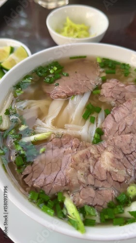 Vietnamese phobo soup, national food in Asia, Vietnamese culture and cuisine. Pho bo soup with beef and noodles, served with herbs and onions. A beautiful serving of the dish at the cafe. Photo for me