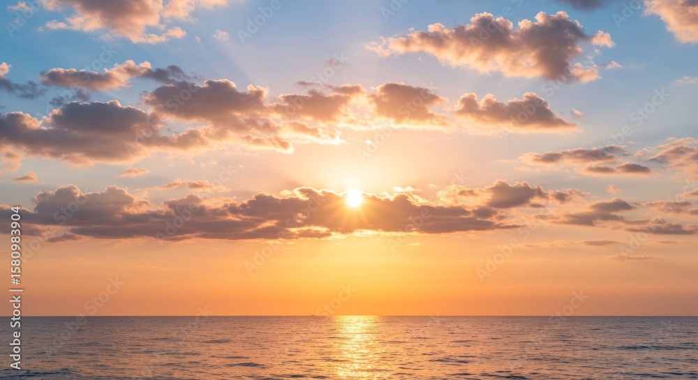 Fototapeta premium Golden Hour Sun Nestled Between Layered Clouds Above a Calm Sea