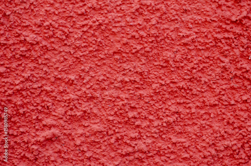 Vivid red stucco wall with rough texture, perfect for backgrounds, posters, and modern graphic projects. Ideal for architectural details and vibrant visual concepts.