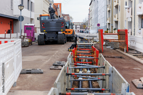 New modern insulated urban pipeline installation construction site  exposed underground pipes in shored trenches. Insulated steel pipes lie connection engineering infrastructure upgrade work