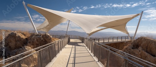 Elevated walkway with a modern fabric canopy offers scenic desert views.