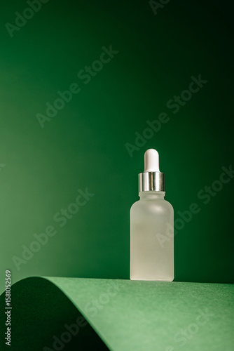 A frosted dropper bottle of facial serum stands against a green background, perfect for use in skincare branding, eco-packaging design, beauty ads, or wellness visuals.