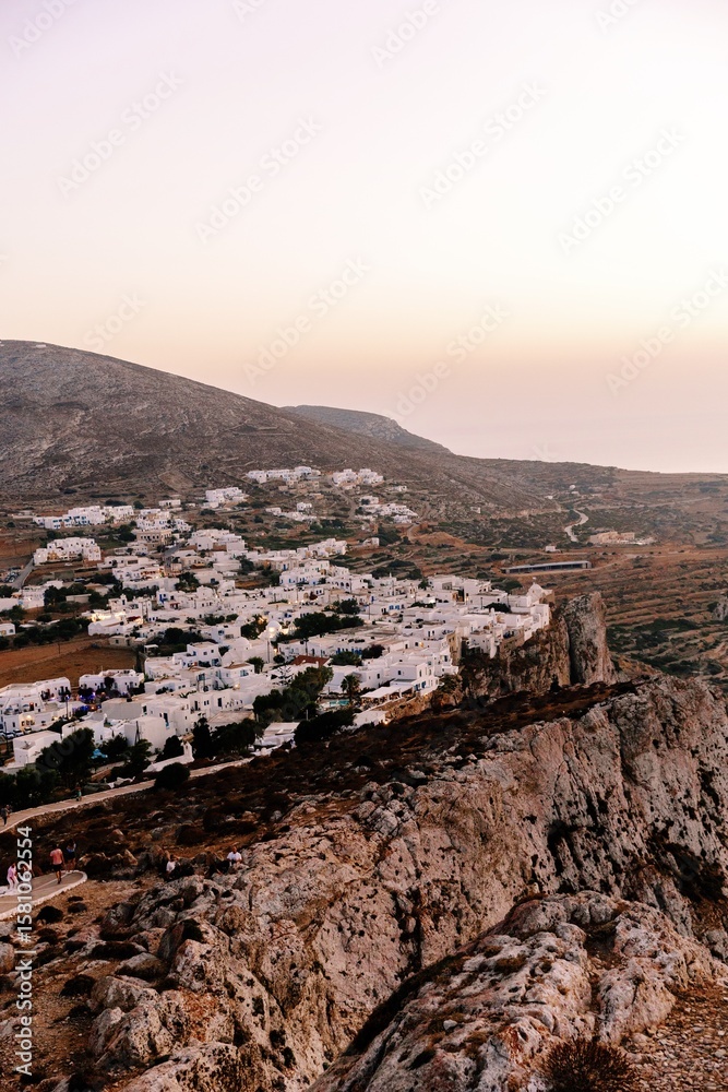 Naklejka premium Cliffside View of Traditional Whitewashed Village in Folegandros at Sunset