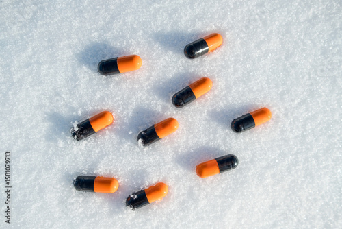 A group of pills are scattered on the snow
