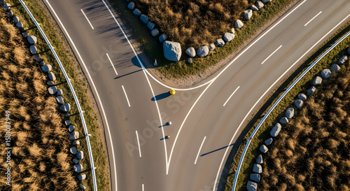 Aerial view of a road junction with decorative rocks at the roadside in alpine region