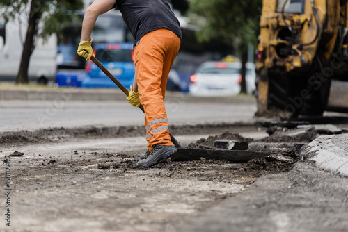 Billede på lærred Road repair work in a busy urban area with construction crew tackling asphalt re