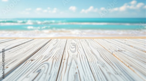 Clear view of wooden boardwalk leading to serene beach and gentle waves on sunny day