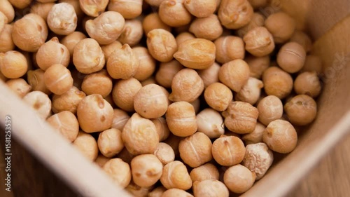 Dried chickpeas in cardboard packaging. Organic garbanzo ingredient. Top view. Rotation