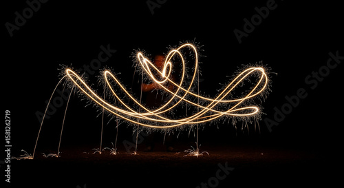 Abstract light painting of sparkler trails in the dark.