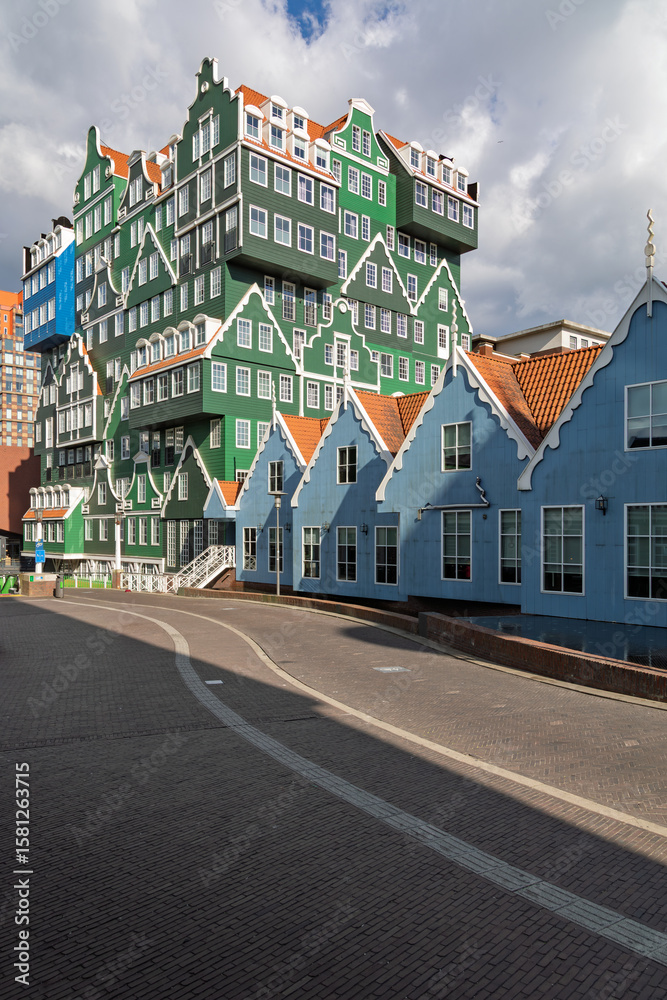 Obraz premium This captivating photo showcases the unique, stacked traditional Dutch house architecture of the Inntel Hotels in Zaandam, blending classic style with modern design under a dramatic sky.