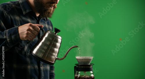 Barista with a beard carefully brewing fresh coffee using a pour-over method on a chromakey background.