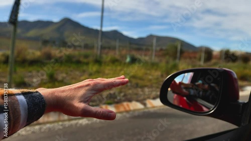 Hand Playing in the Wind Through Car Window on Road Trip