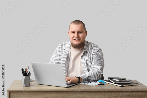 Young man with laptop worki...