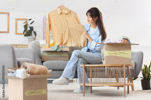 Young woman packing shirt f...