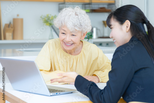 リビングでシニア女性と商談をするビジネスウーマン