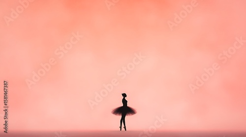 Silhouette of a ballerina poised gracefully on a stage with a soft pink backdrop