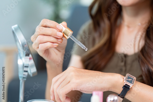 Skin Care Application. Woman testing serum on her wrist for hydration.