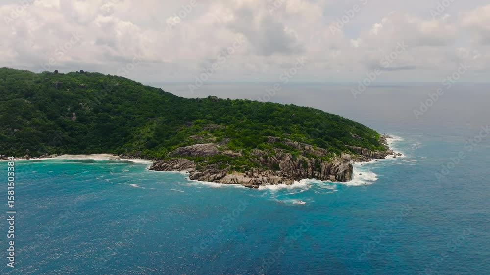 Rocky island coastline with deep blue water and lush vegetation. Felicite, Seychelles. Rocky island coastline with deep blue water and lush vegetation. Felicite, Seychelles.