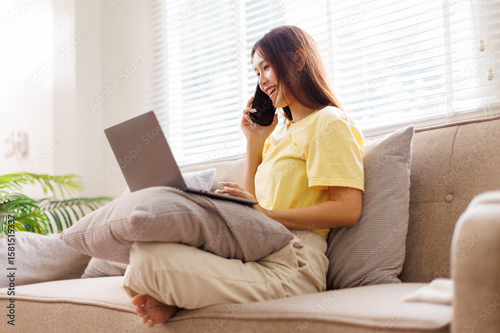 Fototapeta premium Joyful happy young Caucasian asian woman resting on sofa in apartment call on mobile phone internet on smartphone, social network app user, leisure, communication concept 