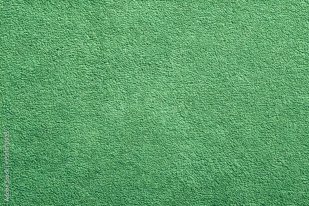 Fototapeta premium A detailed close-up of an eye-catching, vibrant green carpet. The texture of the carpet is visible, and the color is a bright, inviting green