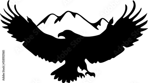 Silhouette of an eagle in flight with wings spread wide against a backdrop of mountain peaks view