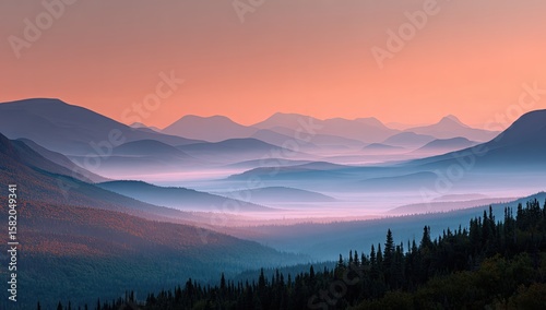 Serene sunrise over a vast, misty mountain range, showcasing layers of blue and purple hues, with a foreground of dark evergreen trees