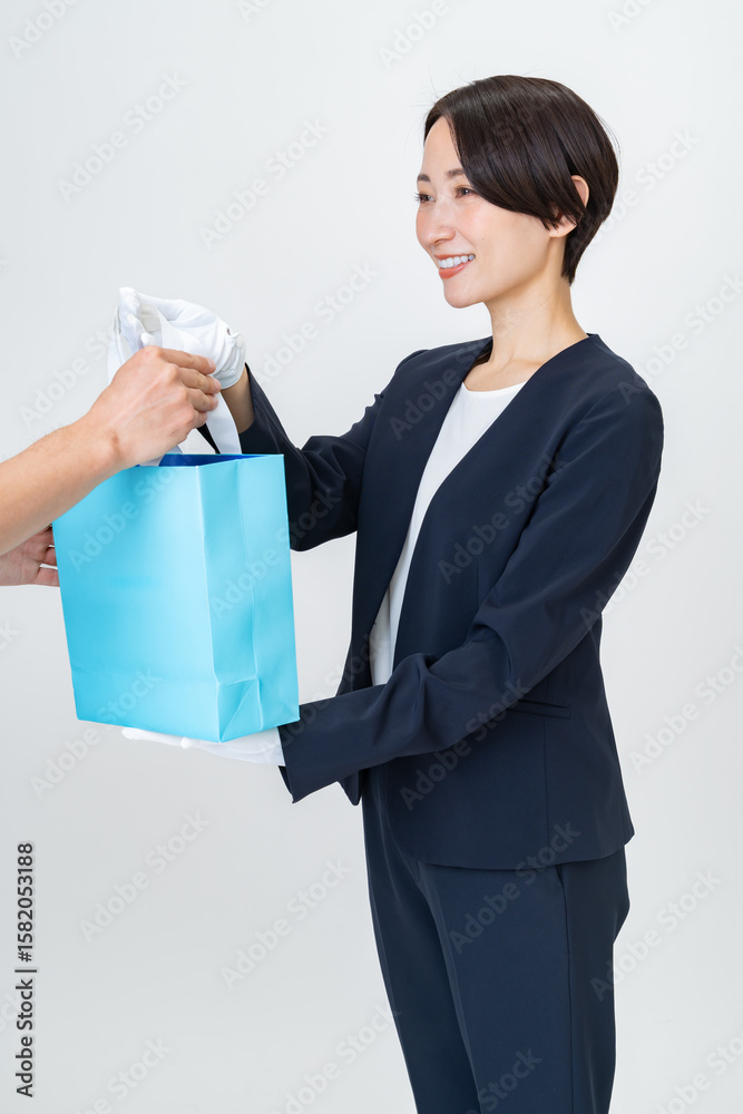 袋を持つスーツを着た女性 袋を持つスーツを着た女性