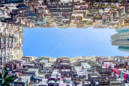 Dense High-Rise Residential Building Creating Unique Frame in Hong Kong. Low-angle view captures fascinating density of residential high-rise buildings in China, forming rectangular frame of clear sky