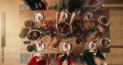 Festive, reunion and people in home, dinner and celebration of Christmas with food at night or meal. Above, group and family with feast for thanksgiving, evening and together on holiday in house